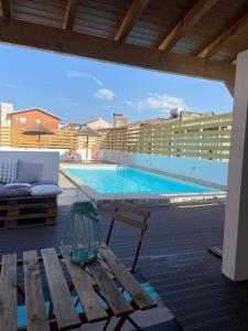 - une vue sur une piscine avec un banc et un bâtiment dans l'établissement Casa dos Carvalhos, à Coimbra