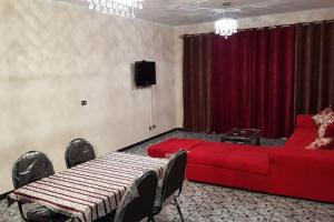een woonkamer met een rode bank en een tv bij Fantastic Apartment Near Cairo Airport in Caïro