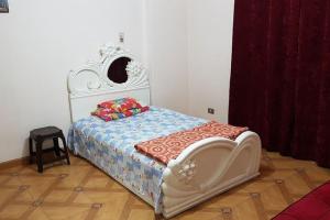 a bedroom with a bed with a white headboard at Fantastic Apartment Near Cairo Airport in Cairo