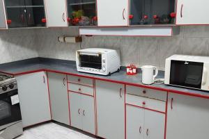 eine Küche mit einer Mikrowelle und einem Toaster in der Unterkunft Fantastic Apartment Near Cairo Airport in Kairo