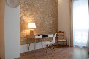 einen Schreibtisch mit einer Lampe und einem Stuhl in einem Zimmer in der Unterkunft EL Paso in Alicante