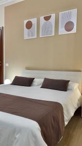 2 camas en un dormitorio con 3 cuadros en la pared en Sunset B&B, en Ladispoli