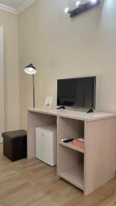 sala de estar con escritorio, TV y lámpara en Sunset B&B, en Ladispoli