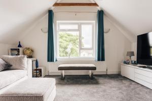 a living room with a couch and a window at Private Two Bedroom Residence in Southbourne - Private Parking - Off the High Street - Minutes Away from the Beach in Bournemouth