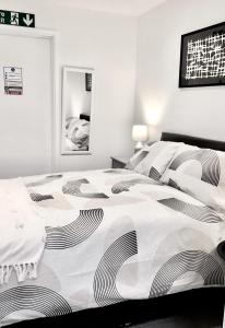 a bedroom with a bed with a black and white comforter at Dunamis Staycation 3 in Croydon