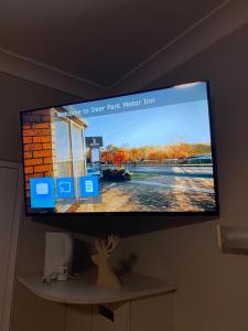 TV de pantalla plana colgada en la pared en Deer Park Motor Inn Armidale en Armidale