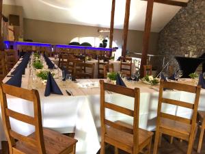 a long table with a white table cloth and wooden chairs at Le Gite De Malchamps in Spa
