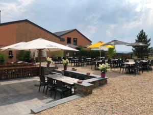 a patio with tables and chairs and umbrellas at Le Gite De Malchamps in Spa