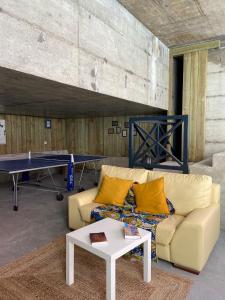 a living room with a couch and a ping pong table at Casa dos Carvalhos in Coimbra
