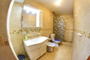 a bathroom with a sink and a toilet and a mirror at Departamento Centro con cochera gratis in Paraná