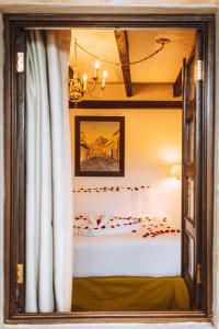 a reflection of a bedroom with a bed in a mirror at El Carmen Hotel in Antigua Guatemala