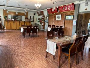 a restaurant with tables and chairs in a room at Ye Jiang Hua Homestay in Meishan