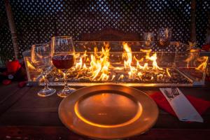 a table with a plate of wine glasses and a fireplace at El Carmen Suites in Antigua Guatemala