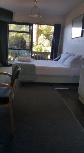 a bedroom with a bed and a chair and a window at Alpine Chalets in National Park