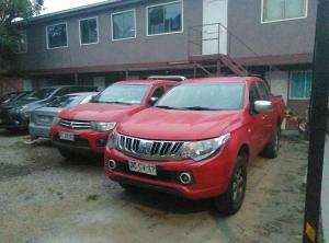 two red trucks parked in front of a building at Alojamientos JV HABITACIONES in Nogales