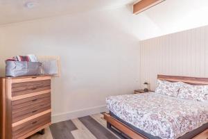 1 dormitorio con cama y tocador de madera en Cozy Bear Den - Sauna New Kitchen Fireplace Large Tv Wifi Indoor Sauna, en Tofte