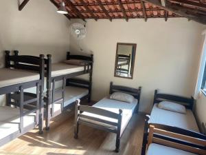 a room with four bunk beds and a mirror at Hostel Blue House Búzios in Búzios