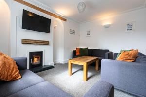 a living room with couches and a fire place at Ayr Farmhouse in St Ives