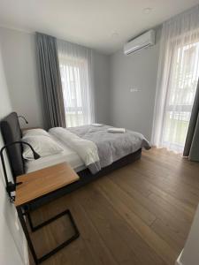 a bedroom with a bed and a wooden floor at Sunset Apartment at Sventosios Vartai in Palanga