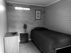ein Schlafzimmer mit einem Bett und einem Tisch mit einer Lampe in der Unterkunft Alojamientos JV HABITACIONES in Nogales