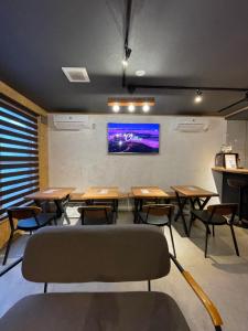 a classroom with tables and chairs and a tv on the wall at Arura Sapporo in Sapporo