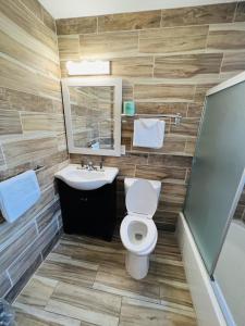 ein Badezimmer mit einem WC, einem Waschbecken und einem Spiegel in der Unterkunft Haiban Inn Jersey City in Jersey City