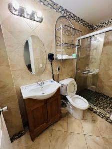 a bathroom with a sink and a toilet and a mirror at Haiban Inn Jersey City in Jersey City