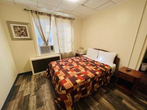 a hotel room with a bed and a window at Haiban Inn Jersey City in Jersey City