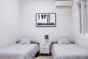 ein Schlafzimmer mit 2 Betten und einem Bild an der Wand in der Unterkunft BEST LOCATION apartment in MARBELLA. BEACHFRONT!! in Marbella