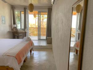a bedroom with a large bed and a balcony at Perro Surfero Hotel in Todos Santos