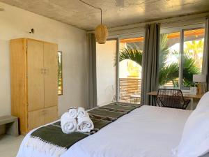 a bedroom with a bed with towels on it at Perro Surfero Hotel in Todos Santos