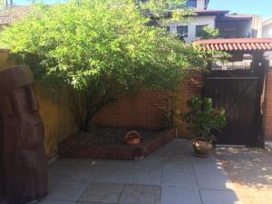 a small garden with a tree and a fence at Toca do Moa in Florianópolis