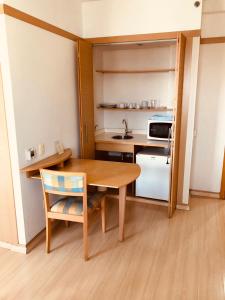 eine kleine Küche mit einem Holztisch und einem Stuhl in der Unterkunft Classic Flat do Eduardo in São Paulo
