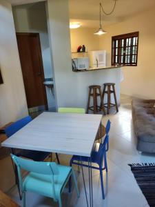 une salle à manger et un salon avec une table et des chaises dans l'établissement Casa Azul Perequê, à Ilhabela