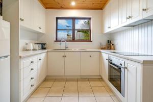 a kitchen with a sink, stove and a window at Blackwood Park Cottages Mole Creek in Mole Creek