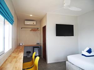 a room with a bed and a tv on a wall at Sand Terrace Beach Bungalows in Baan Tai