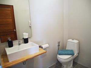 a bathroom with a white sink and a toilet at Sand Terrace Beach Bungalows in Baan Tai