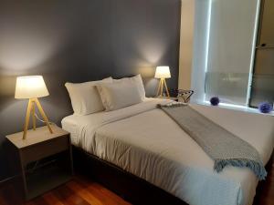 1 dormitorio con 1 cama con 2 lámparas y una ventana en Punto Alameda - Reforma, en Ciudad de México