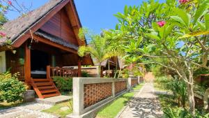 a house with a pathway next to a building at Cersen Resort Lombok in Kuta Lombok