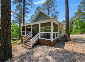 una pequeña casa en el bosque con árboles en Convenient Romantic Hot Tub BBQ 3-night special! en Broken Bow