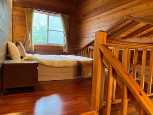 a bedroom with a bed in a log cabin at Ye Jiang Hua Homestay in Meishan