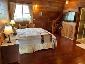 a bedroom with a bed with a television and a staircase at Ye Jiang Hua Homestay in Meishan