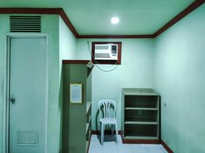 um quarto com uma porta, uma cadeira e uma ventoinha em Parkview Hotel em Cagayan de Oro