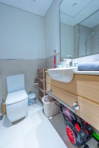 a bathroom with a white toilet and a sink at Cozy Studio In front of Metro Stn - Access to Gym & Pool - BRC in Dubai