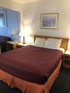 a large bed in a hotel room with two lamps at Four Winds Motel in Depoe Bay