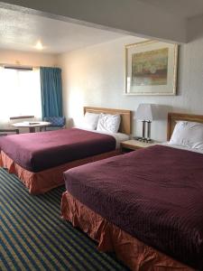 מיטה או מיטות בחדר ב-Four Winds Motel