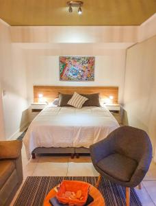 1 dormitorio con 1 cama grande y 1 silla en Studio Exclusivo en Palermo Queens en Buenos Aires