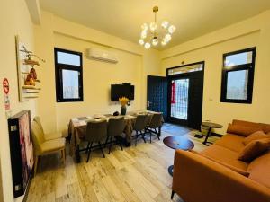 金門禧樂民宿 في Shan-ch'ien: غرفة معيشة مع أريكة وطاولة وكراسي