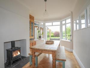 a living room with a table and a fireplace at Summerfield in Conwy