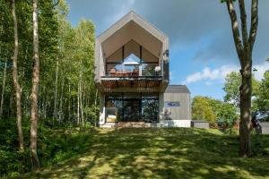 a house in the woods with a balcony at Shakuzen in Niseko